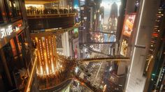 an aerial view of a city at night with lots of tall buildings and neon lights