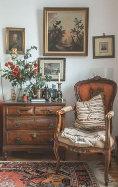 an old chair sits in front of a dresser with pictures on the wall behind it