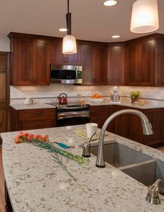 a kitchen with granite counter tops and wooden cabinets