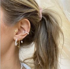 a close up of a person wearing some kind of earring with pearls on it