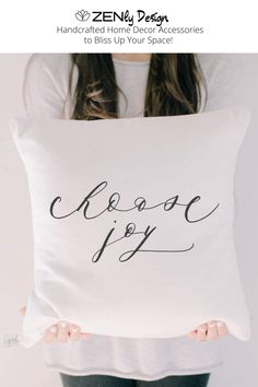 a woman holding a white pillow with the words sweet dreams on it in cursive writing