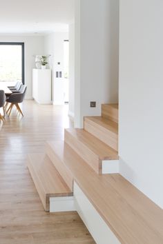 the stairs are made of wood and have white railings that lead up to an open floor plan