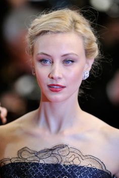 a woman in a strapless black dress posing for the camera with her hand on her hip