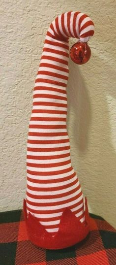 a red and white striped vase sitting on top of a checkered table cloth