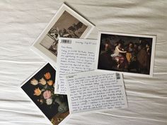 some pictures and letters are laying on a white sheet with flowers in the corner,