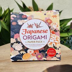 a japanese origami paper pack sitting on top of a wooden table next to plants