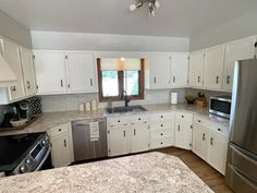 a kitchen with stainless steel appliances and white cabinets