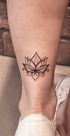 a woman's foot with a lotus tattoo on the left side of her leg