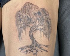 a tattoo on the thigh of a person with a tree and two birds in it