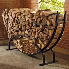 a stack of logs sitting on top of a metal stand next to a brick wall