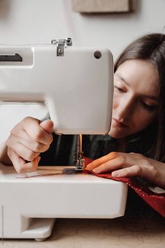 a woman is using a sewing machine to sew carrots