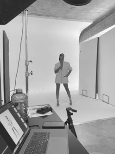 a black and white photo of a woman in front of a camera with a laptop