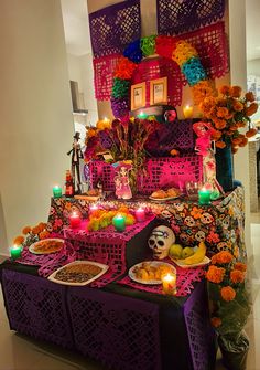 a table topped with lots of food next to candles and flowers on top of it