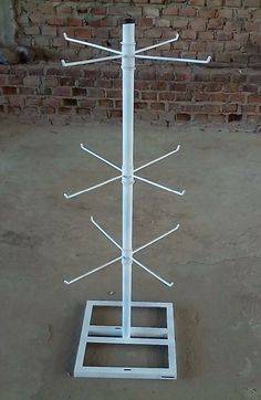 a white pole with four poles on it in front of a brick wall and cement floor