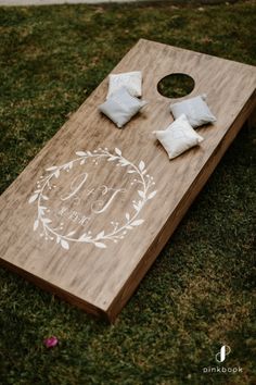 a close up of a cornhole board on the grass with pillows and napkins