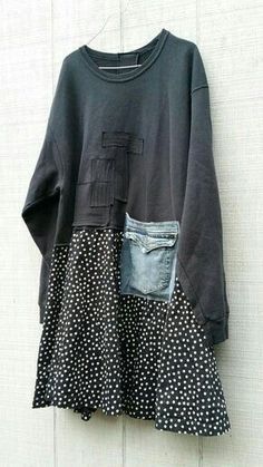 a t - shirt with polka dots on it hanging up against a white wall next to a pair of jeans