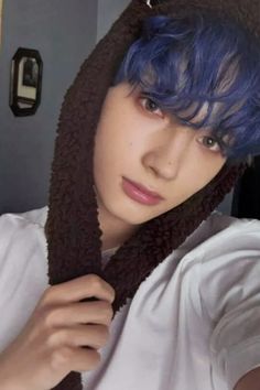 a person with blue hair wearing a hoodie