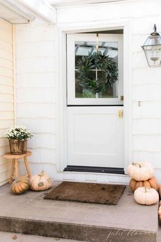 the front door is decorated with pumpkins and other decorations