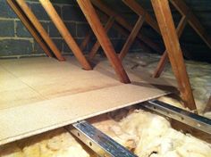 an attic that has been filled with wool and some wooden beams on the floor in front of it