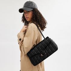 A modern take on an archival 1970s Coach design our structured Tabby shoulder bag is crafted of luxe quilted nappa leather. Finished with our Signature hardware for an iconic touch the 33 is a spacious style with a secure inside zip pocket a convenient outside pocket and plenty of room for essentials including a mini tablet. Keep the leather-and-chain strap long to wear it crossbody or double it for a shorter dressier look. | Coach Tabby Shoulder Bag 33 With Quilting - Women's - Pewter/black Coach Handbags Coach, Coach Bags Handbags Coach, Trendy Coach Shoulder Bag, Coach Bag Blck, Coach Hamdbags, Luxury Handbags Coach, Coach Pillow Tabby Purse, Coach Bags 2021, Black Crossbody Bag Coach