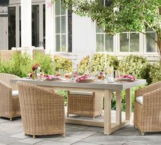 an outdoor dining table with wicker chairs