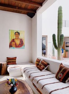 a living room filled with furniture and a painting on the wall next to a coffee table