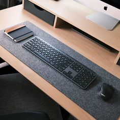 a computer keyboard and mouse pad on a desk