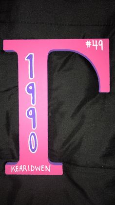 a pink letter shaped like the number one on a black background with purple lettering and numbers