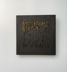 a black and gold painting hanging on the wall