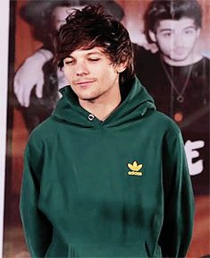 the young man is wearing a green hoodie