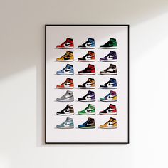 a framed poster with different colored sneakers on it's wall above a white table