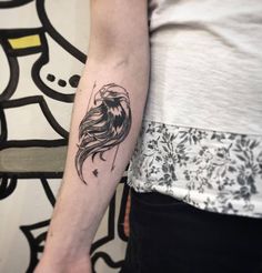 a woman's arm with a tattoo on it that has a bird on it