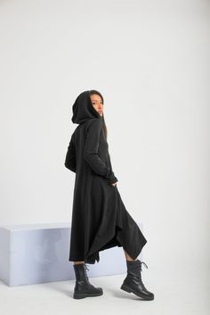 "Asymmetrical multiway hooded dress - a perfect touch for your casual daily style. Featuring a comfy hood, side pockets, and thumbholes - dress for a different and chic look. The fabric is soft viscose-natural, super gentle to the skin, and flows beautifully while walking. The model in the picture is 176cm. ⅼ 5.8 ft. tall and is wearing size S / Color: Black 🌟 INFO: * Worldwide EXPRESS shipping - please provide a phone number for shipping documents * US Sizing XS to 4XL -  size chart available below - all measurements of the body * We offer customization to Personal Measurements & Larger Sizes 5XL, 6XL, 7XL .... 🌟 MATERIAL & CARE * fabric: Cotton Mix * hand wash * cold water 30 degrees * iron at medium temperature 🌟 🌟 🌟 SIZE CHART 🌟 🌟 🌟 SIZE XS Bust: around 33.5\" / 85cm Waist: aro Black Sweatshirt Dress, Shipping Documents, Steampunk Dress, Witch Dress, Dress Asymmetrical, Hooded Dress, Black Sweatshirt, Gothic Dress, Daily Style