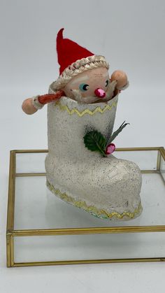 a glass figurine with a santa hat and boots