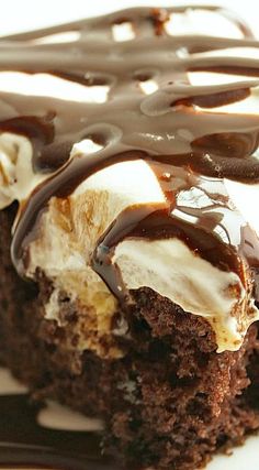 a piece of chocolate cake covered in ice cream and drizzled with chocolate