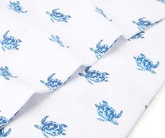 a white shirt with blue turtle print on the front and bottom, rolled up in half