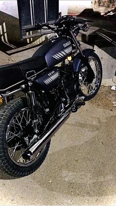 a black motorcycle parked in front of a building