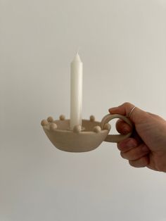 a person is holding a candle in a bowl