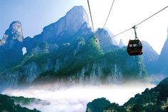 a cable car going through the mountains with fog