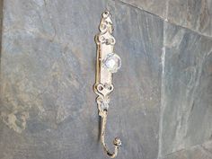 an ornate metal hook on the side of a stone wall