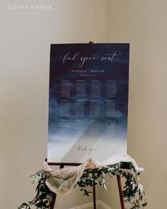 an easel with a wedding seating chart on it