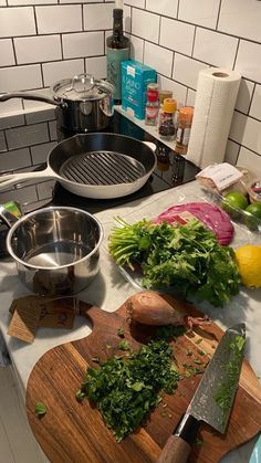 the kitchen counter is cluttered with vegetables and cooking utensils