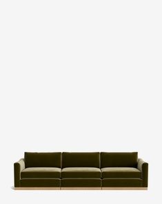 a green couch sitting in front of a white wall