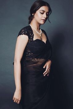 a woman in a black dress posing for the camera