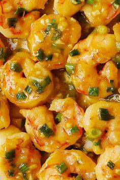 cooked shrimp with green onions and sauce in a white bowl