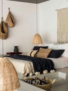 a bed room with a neatly made bed and lots of hanging hats on the wall