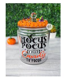 a glass jar filled with orange candies on top of a table