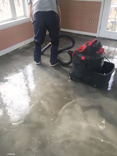 a man is using a vacuum to clean the floor