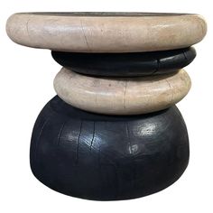 a stack of three black and white stools sitting on top of each other in front of a white background