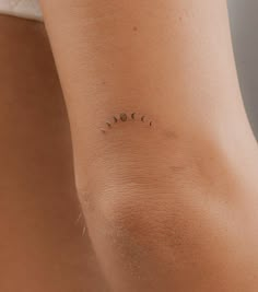 the back of a woman's arm with three small dots on her left side